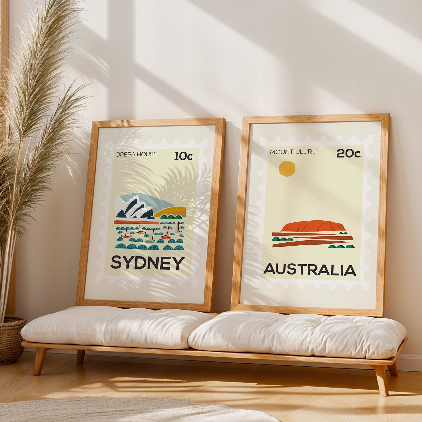 Two framed prints of Sydney and Australia on a wall with a bench below.