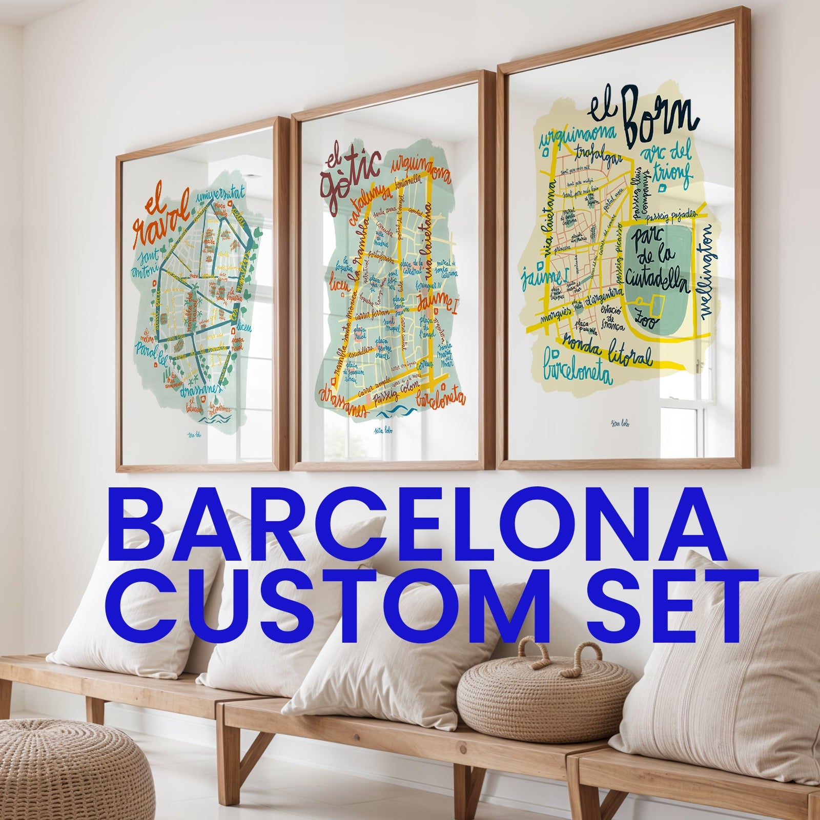 Three framed maps of Barcelona on a wall above a wooden bench with decorative pillows.