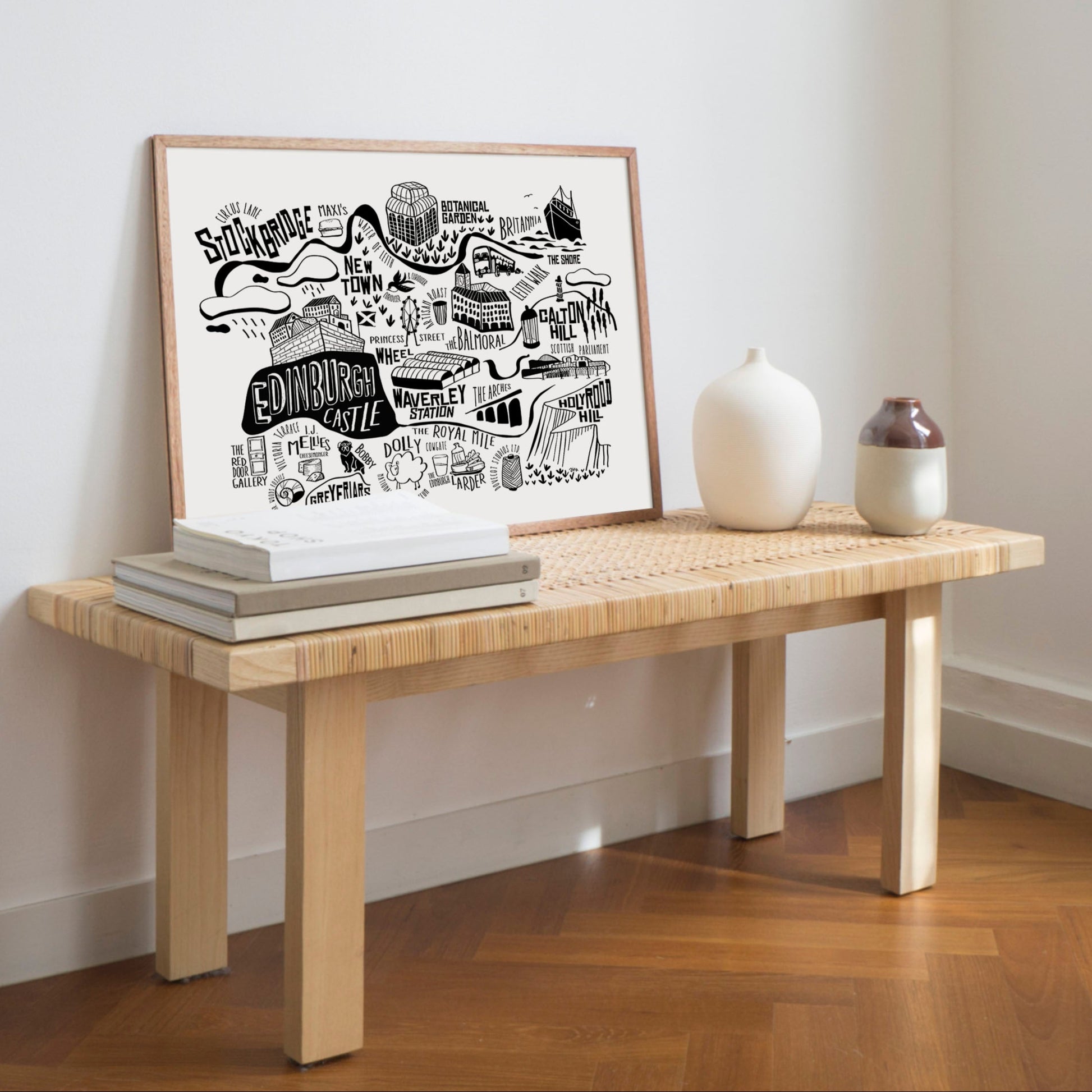 Wooden bench with framed artwork and decorative items against a white wall.
