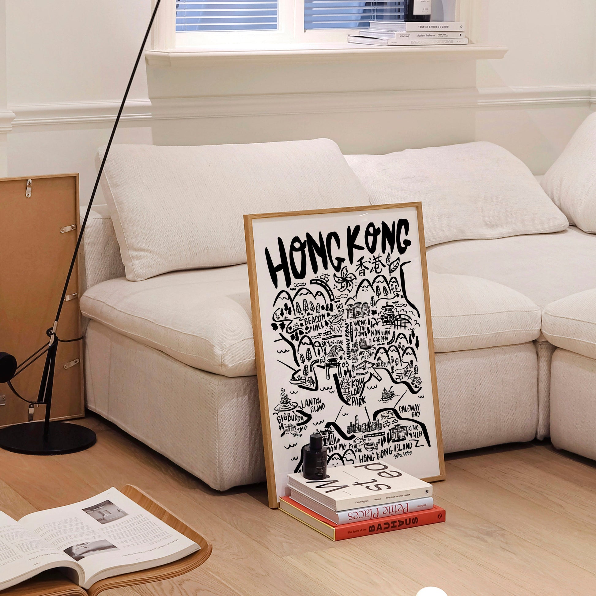 Living room with a white sofa, floor lamp, and a framed poster on a stand.