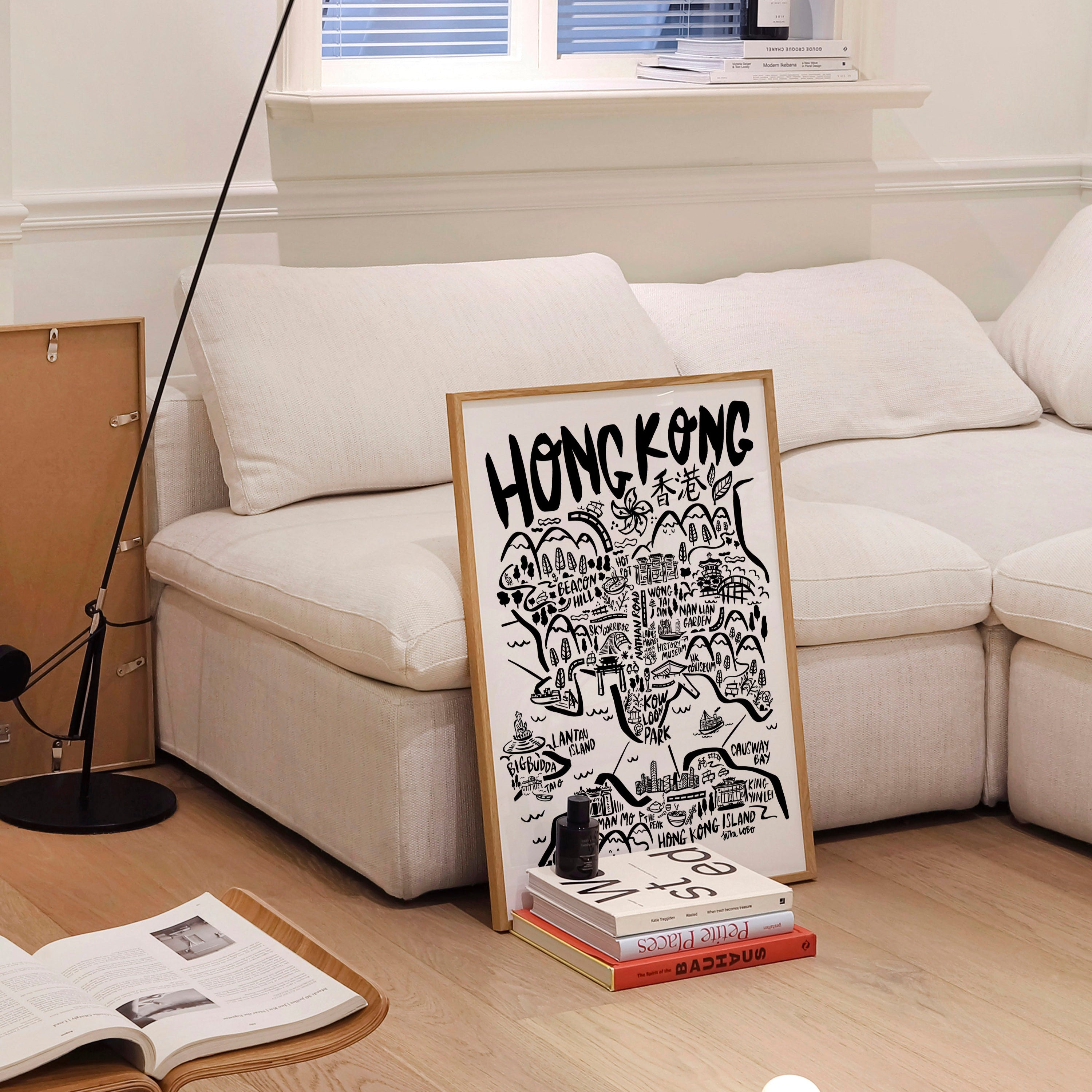 Living room with a white sofa, floor lamp, and a framed poster on a stand.