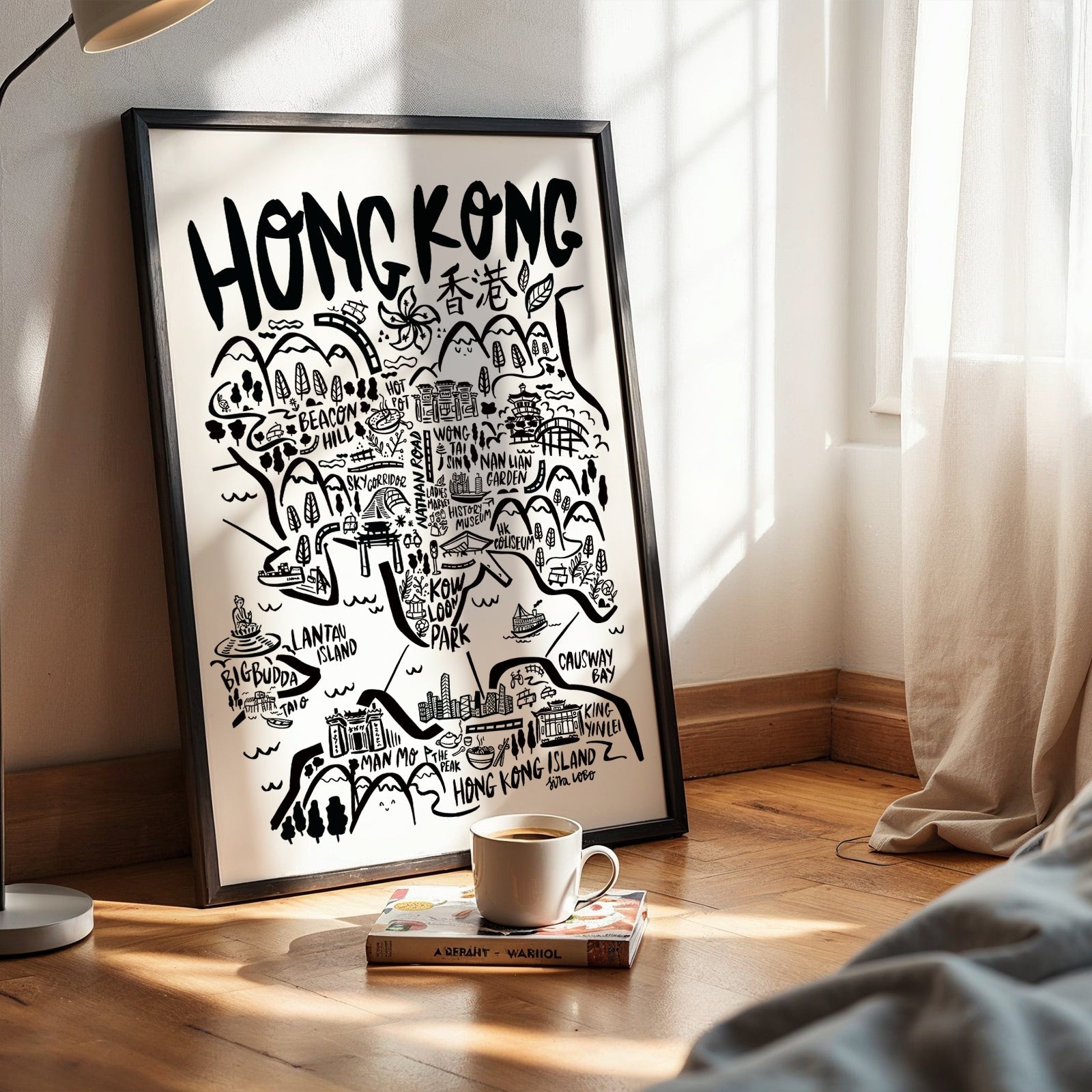 Framed map of Hong Kong on a wall with a cup and book on a surface below.