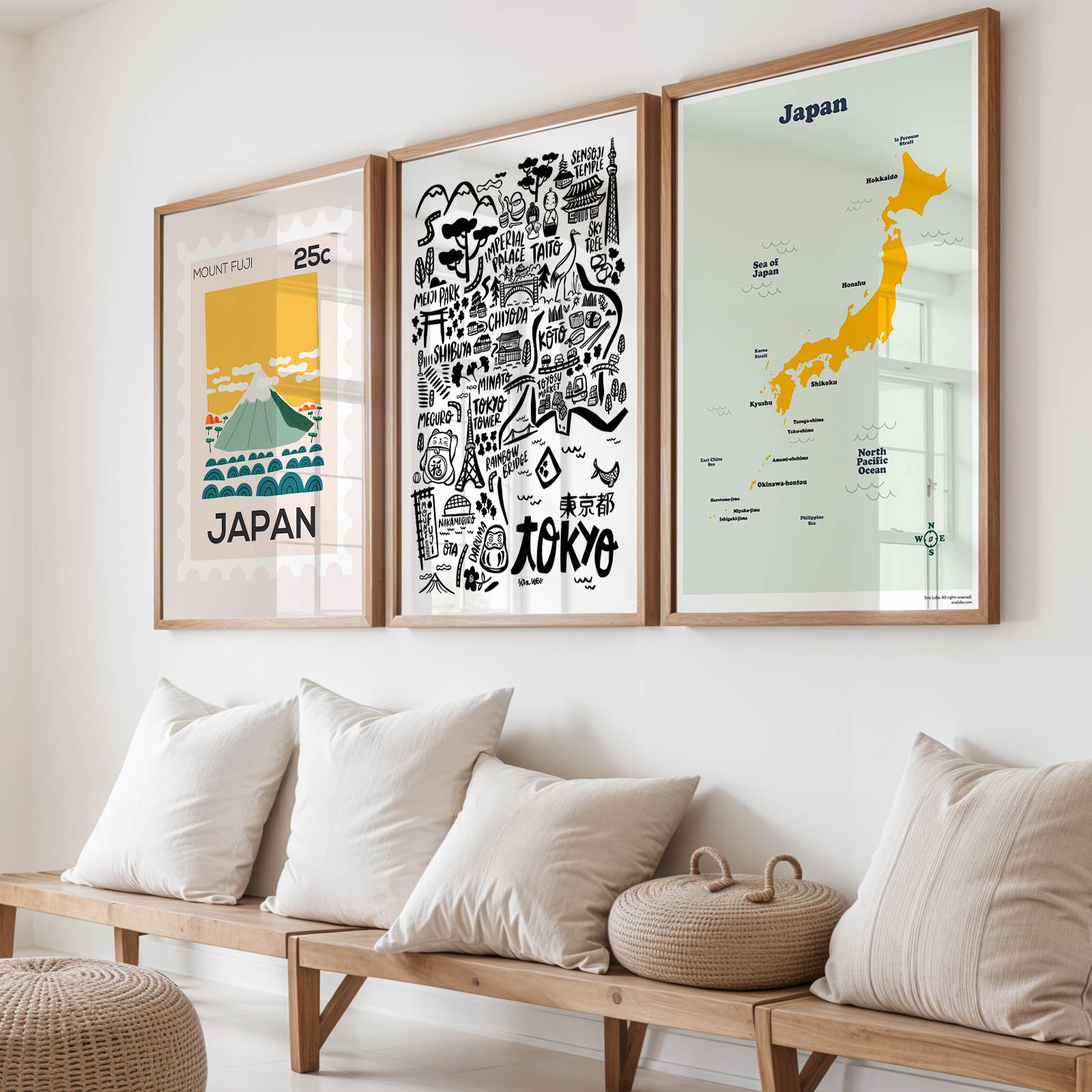 Three framed prints of Japan on a wall above a wooden bench with cushions.