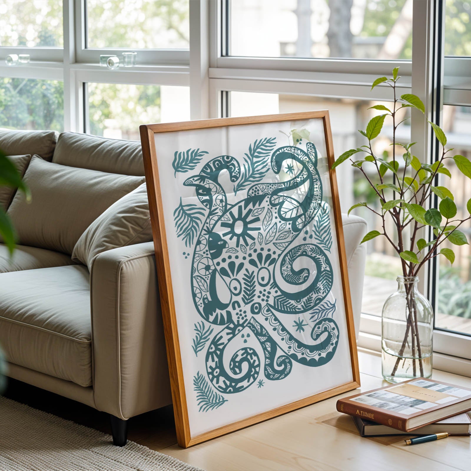 Decorative framed artwork on a table in a living room with a couch and plants.