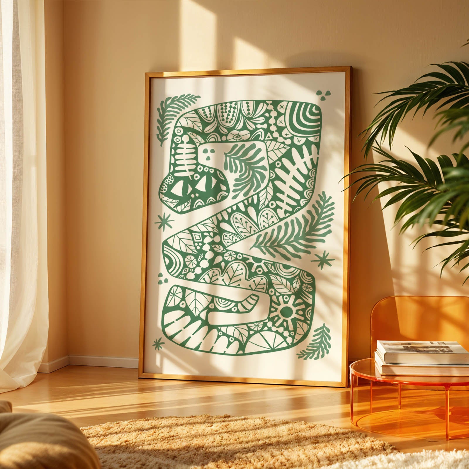 Decorative wall art of a snake with green patterns in a gold frame, placed in a room with a plant and table.