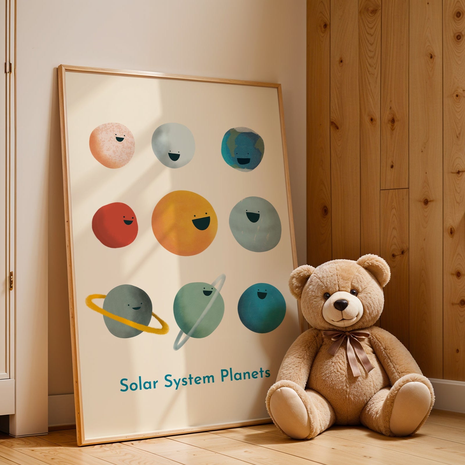 Teddy bear sitting next to a framed diagram of solar system planets on a wooden floor.