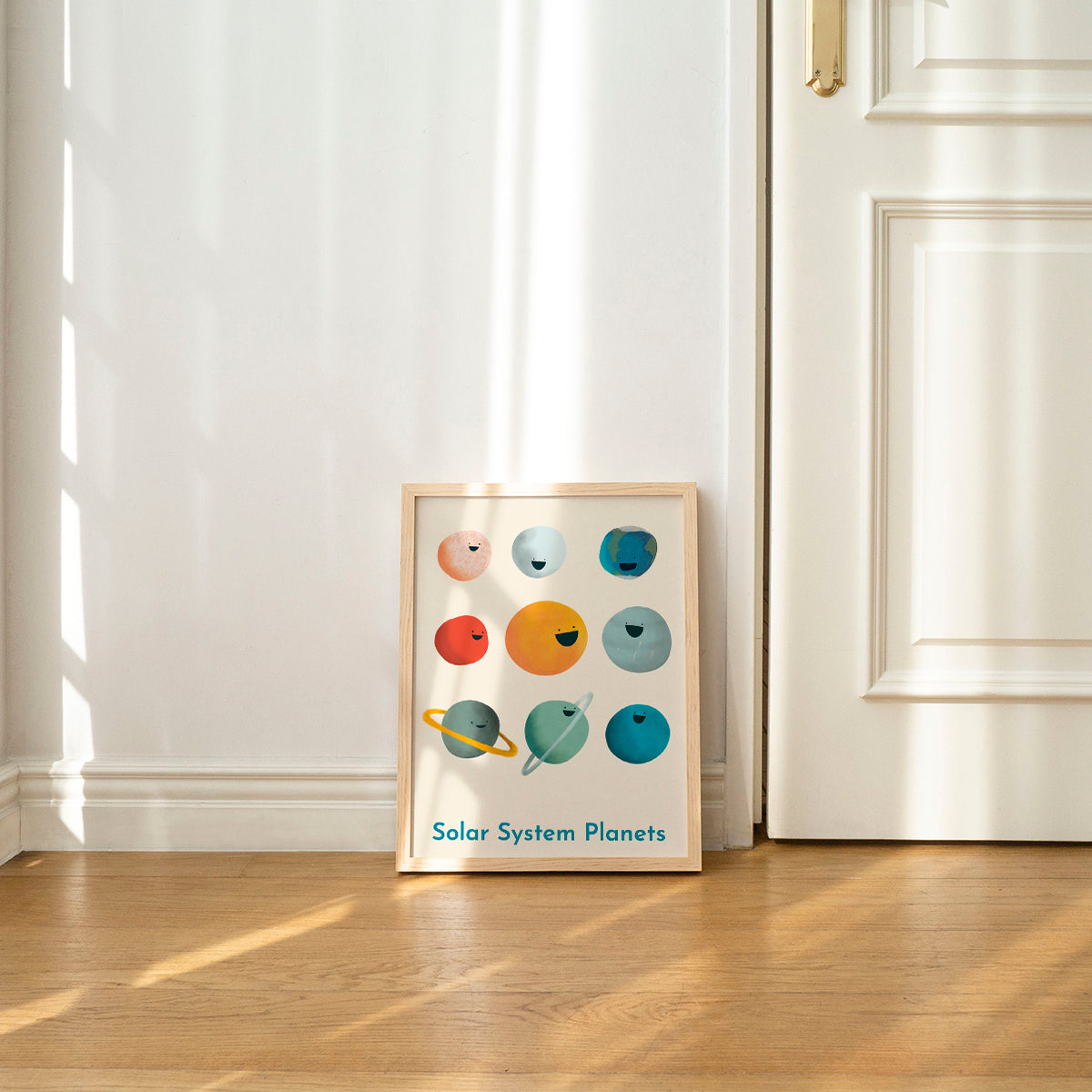 Framed poster of solar system planets on a wall in a room with wooden floor and white walls.