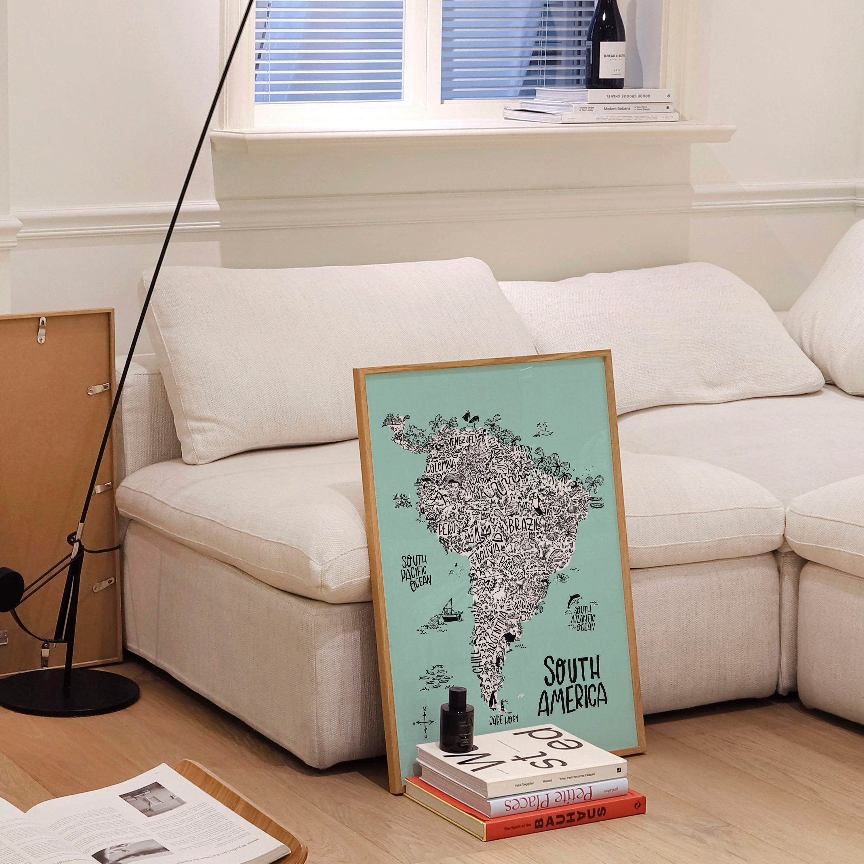 Living room with a white sofa, floor lamp, and a map of South America on a stand.