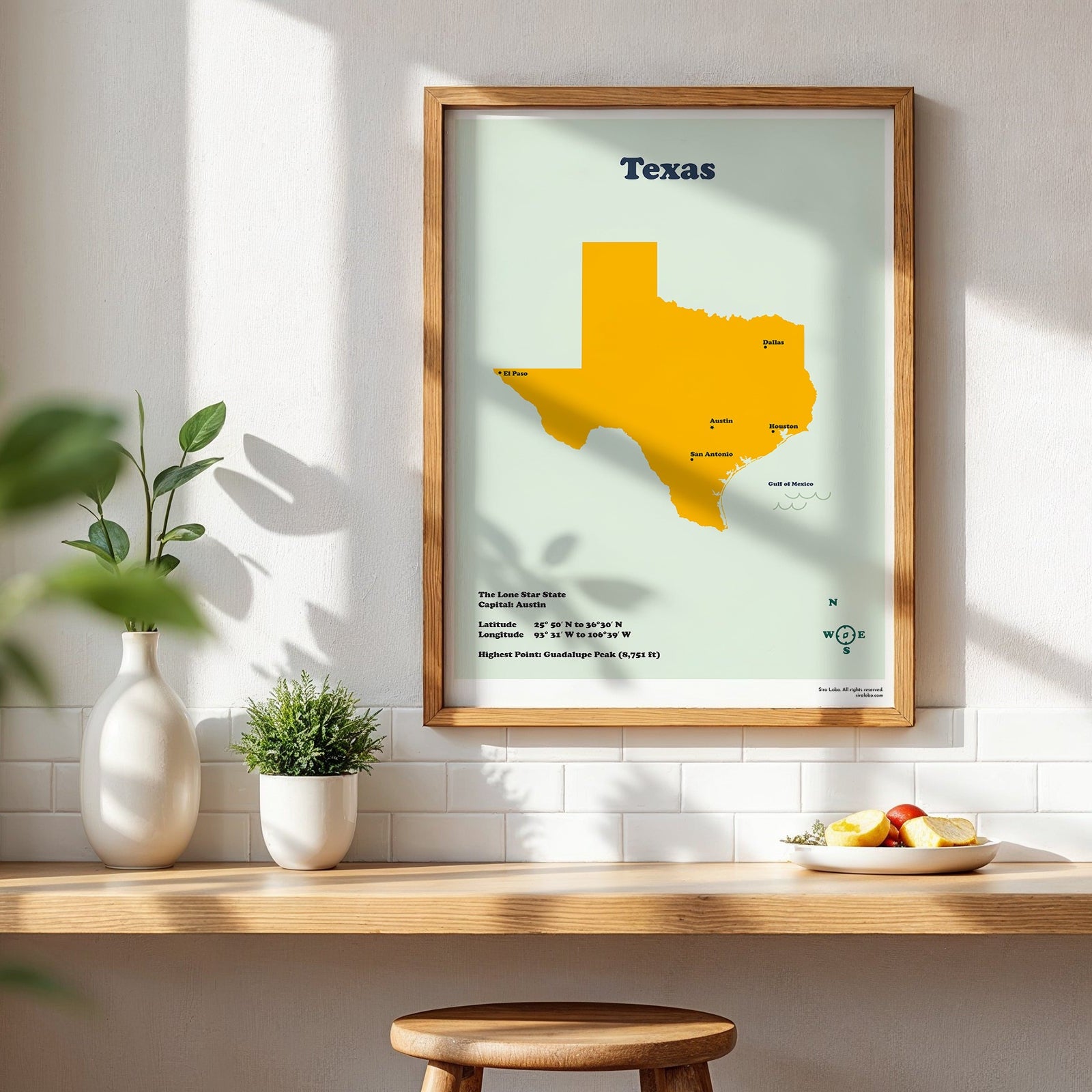 Framed map of Texas on a wall above a wooden shelf with decor items.