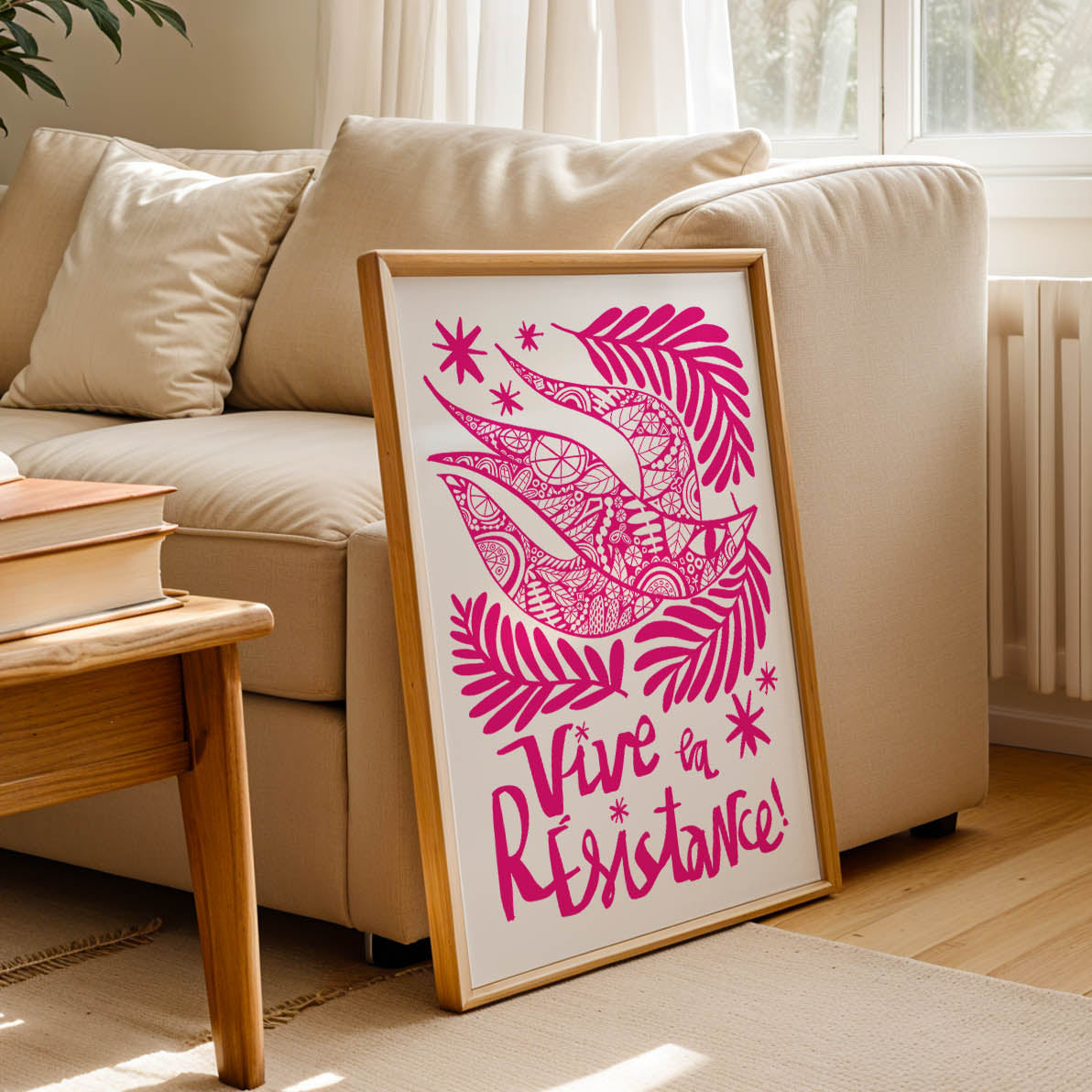 Living room with a pink framed artwork on a table, books, and a radiator.