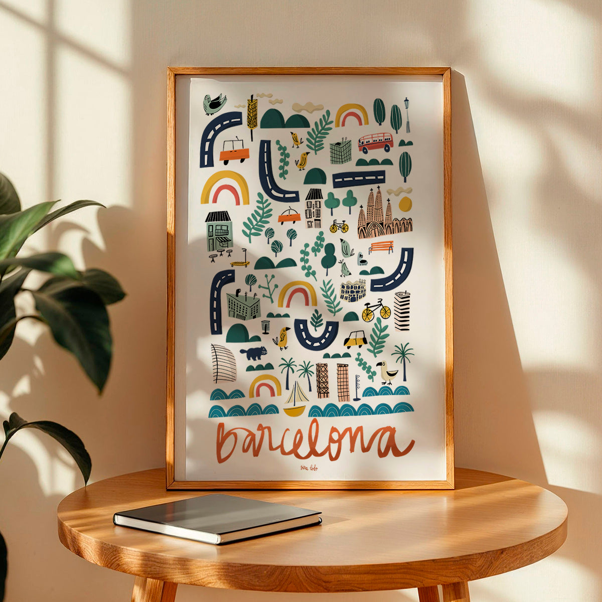 Framed artwork with 'Barcelona' illustration on a wooden table