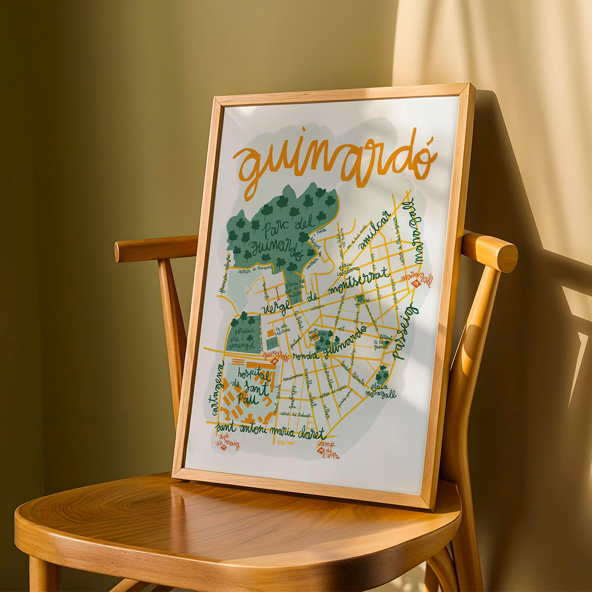Framed map of Guimard on a wooden chair against a beige wall