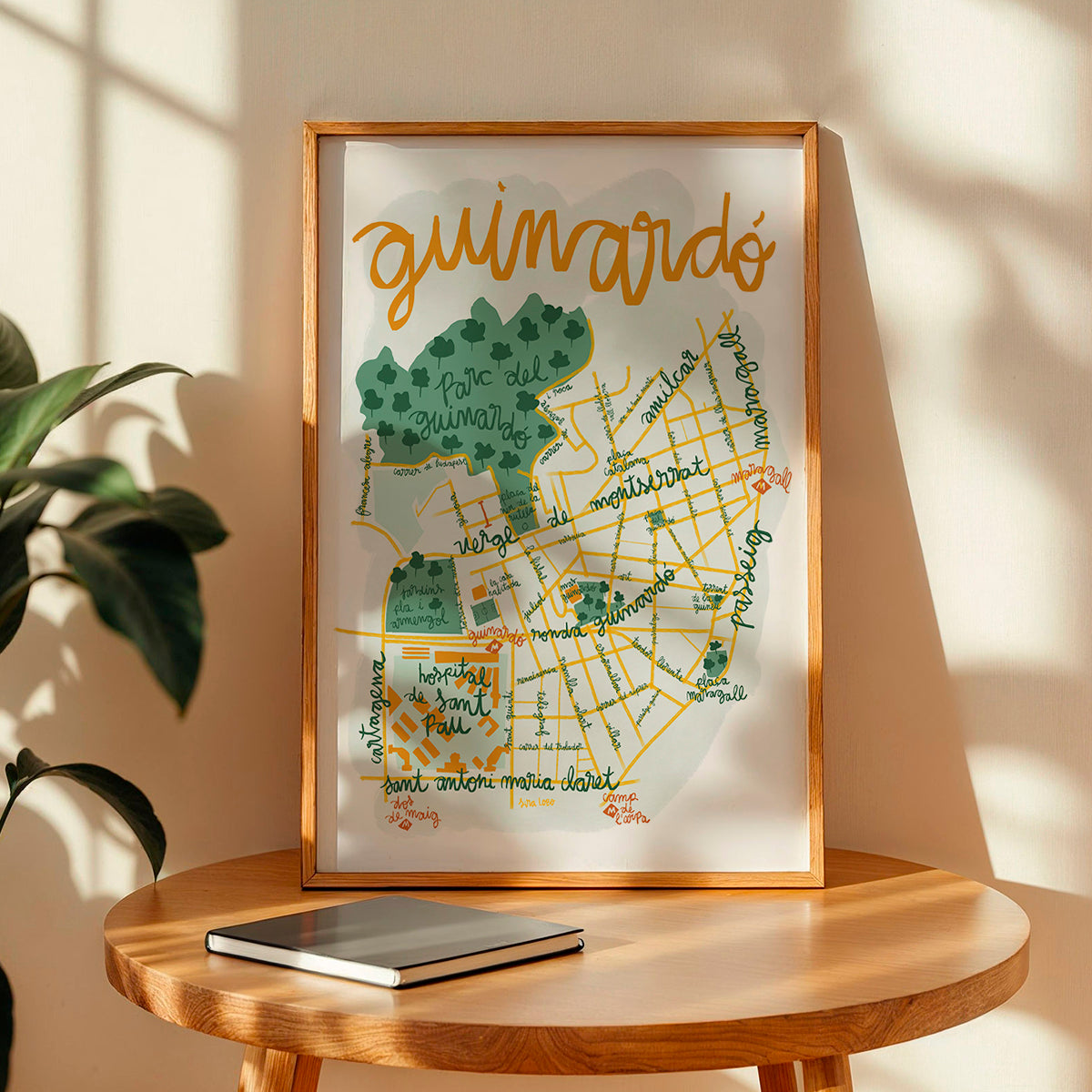 Framed map print of Guimardé on a wooden table with a plant in the background