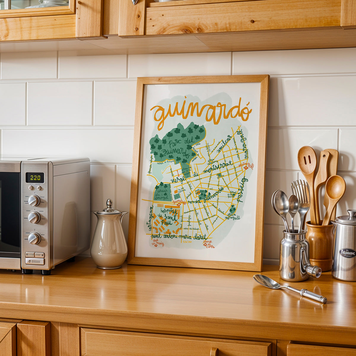 Framed map of Guimardó on a kitchen counter with utensils and appliances.