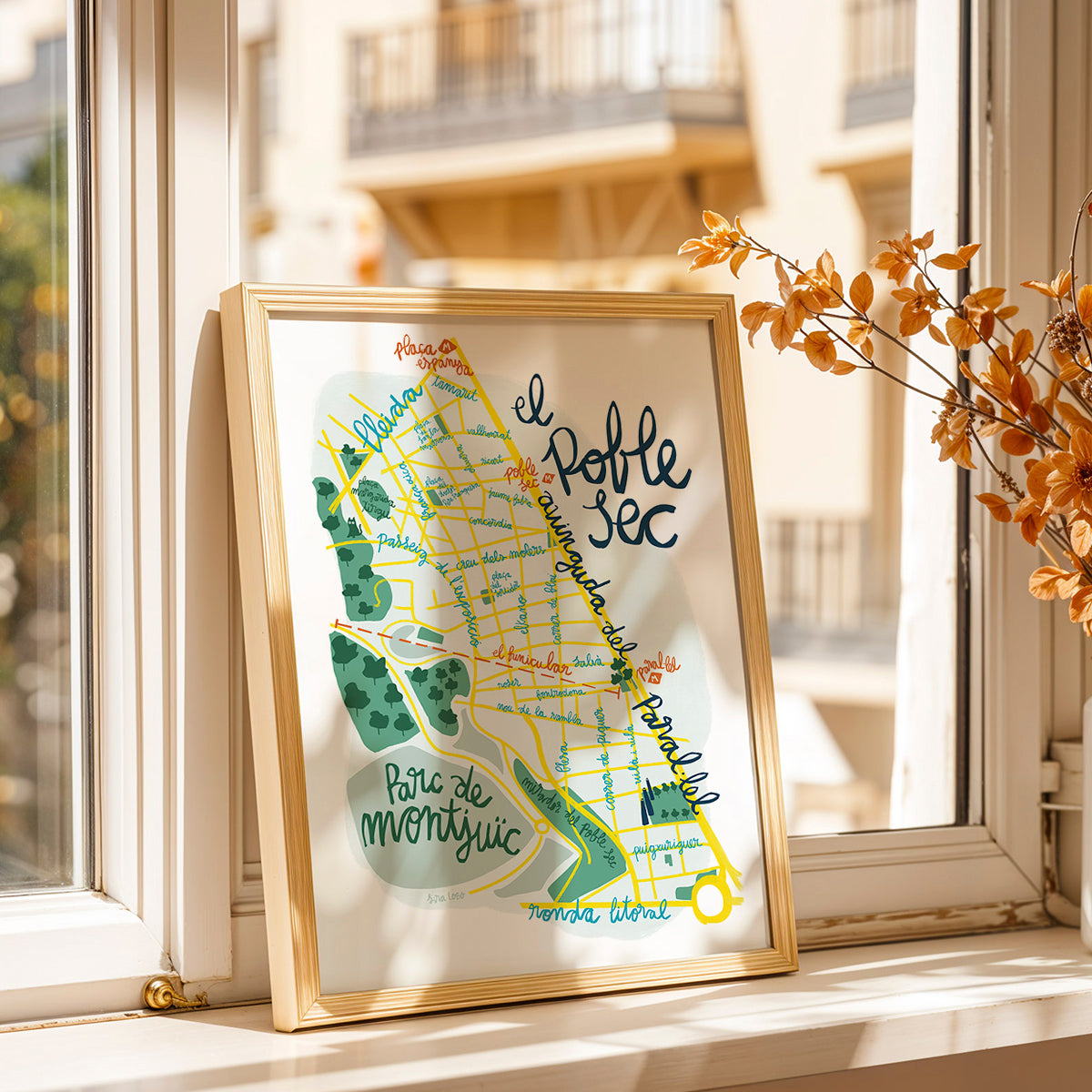 Framed map of Poble Sec in Barcelona on a windowsill with a blurred background