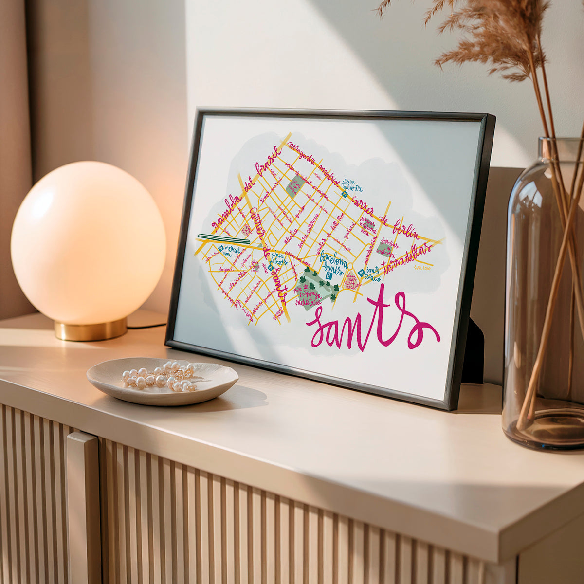 Framed map of Sants in Barcelona on a table with decorative items