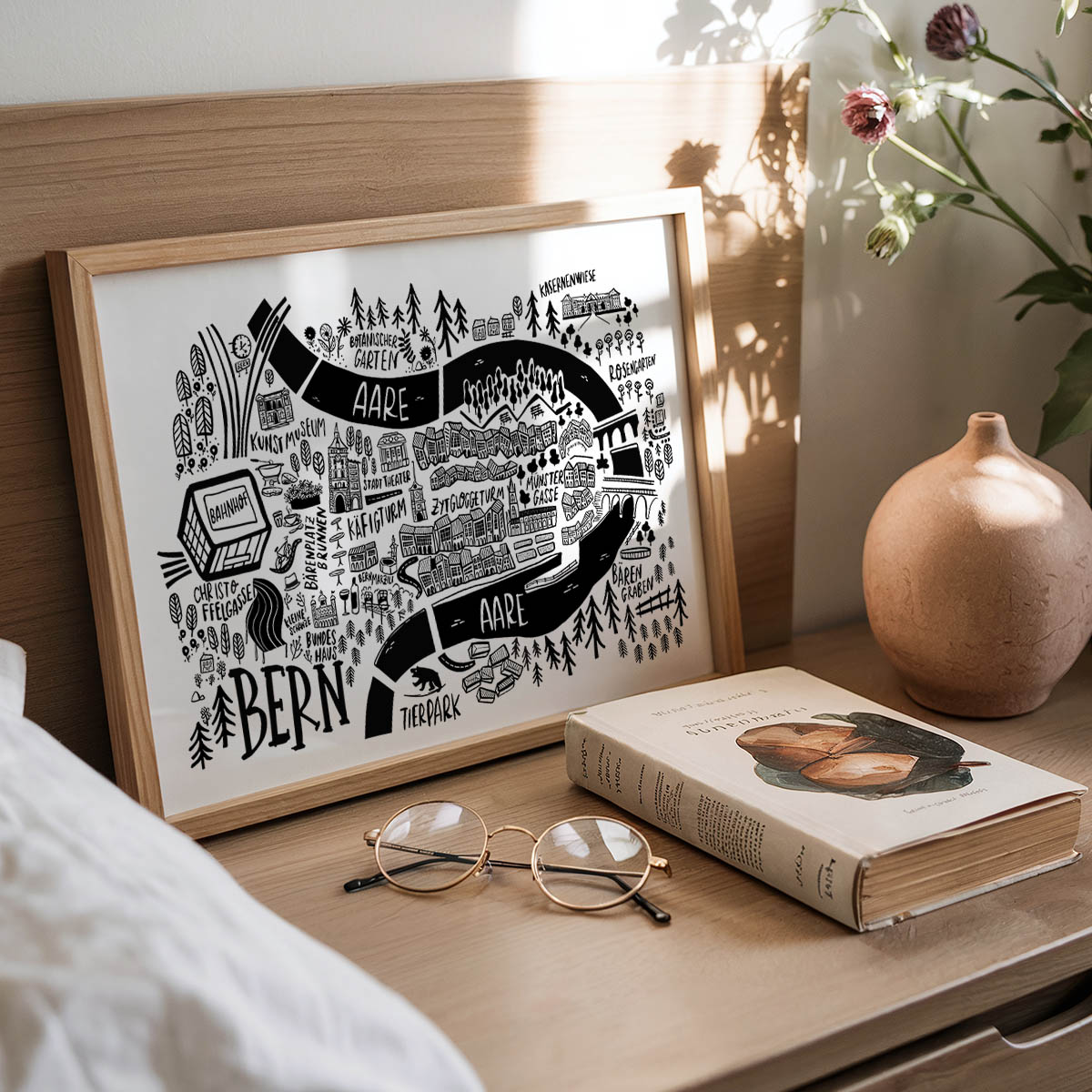 Framed map of Bern with a book and glasses on a wooden surface