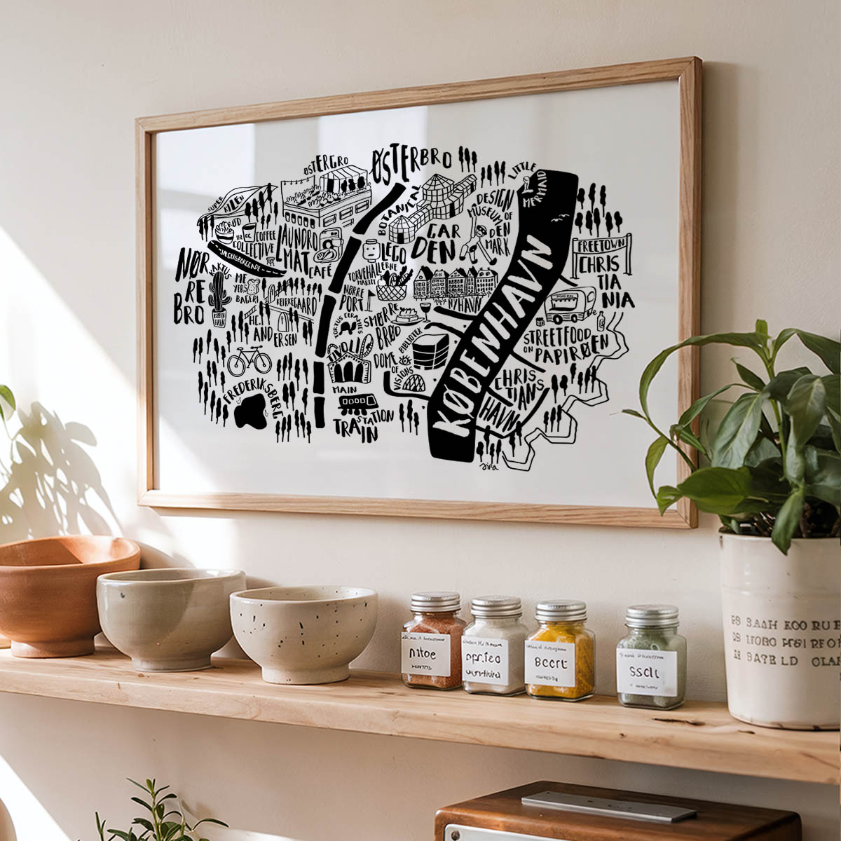 Framed black and white map of Rotterdam on a wall above a wooden shelf with bowls and jars.