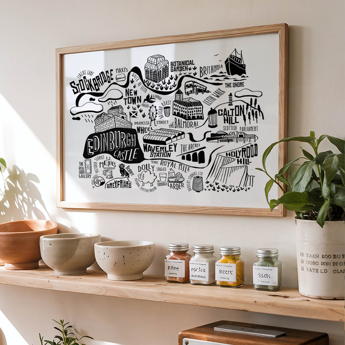 Framed map of Edinburgh on a wall above a shelf with decorative items.
