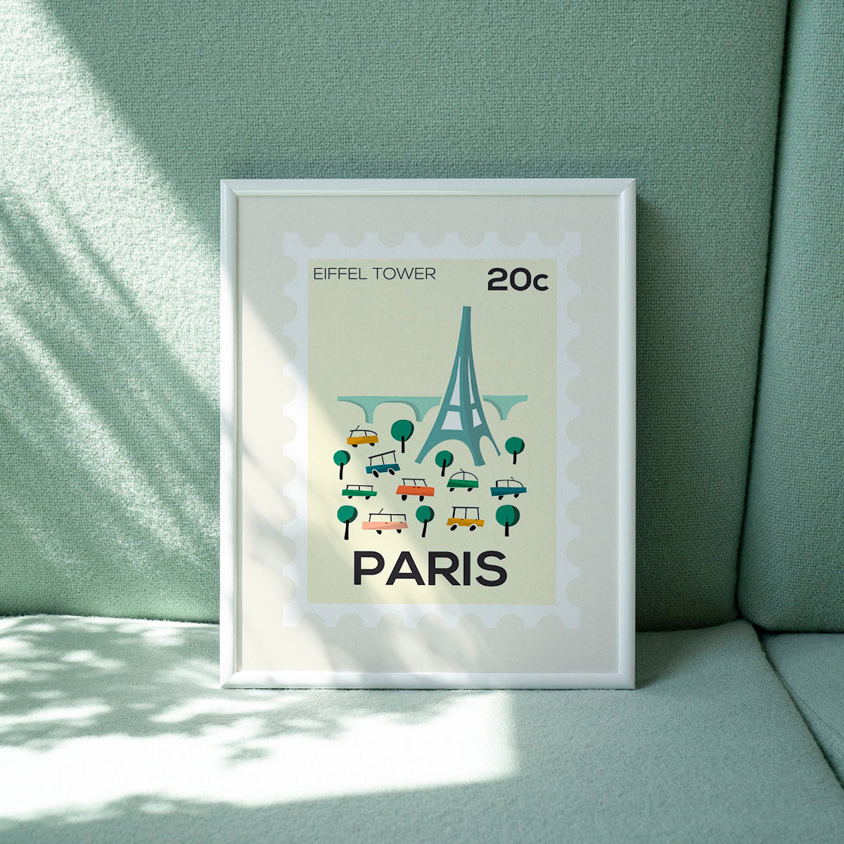 Framed poster of the Eiffel Tower with 'Paris' text on a green wall.