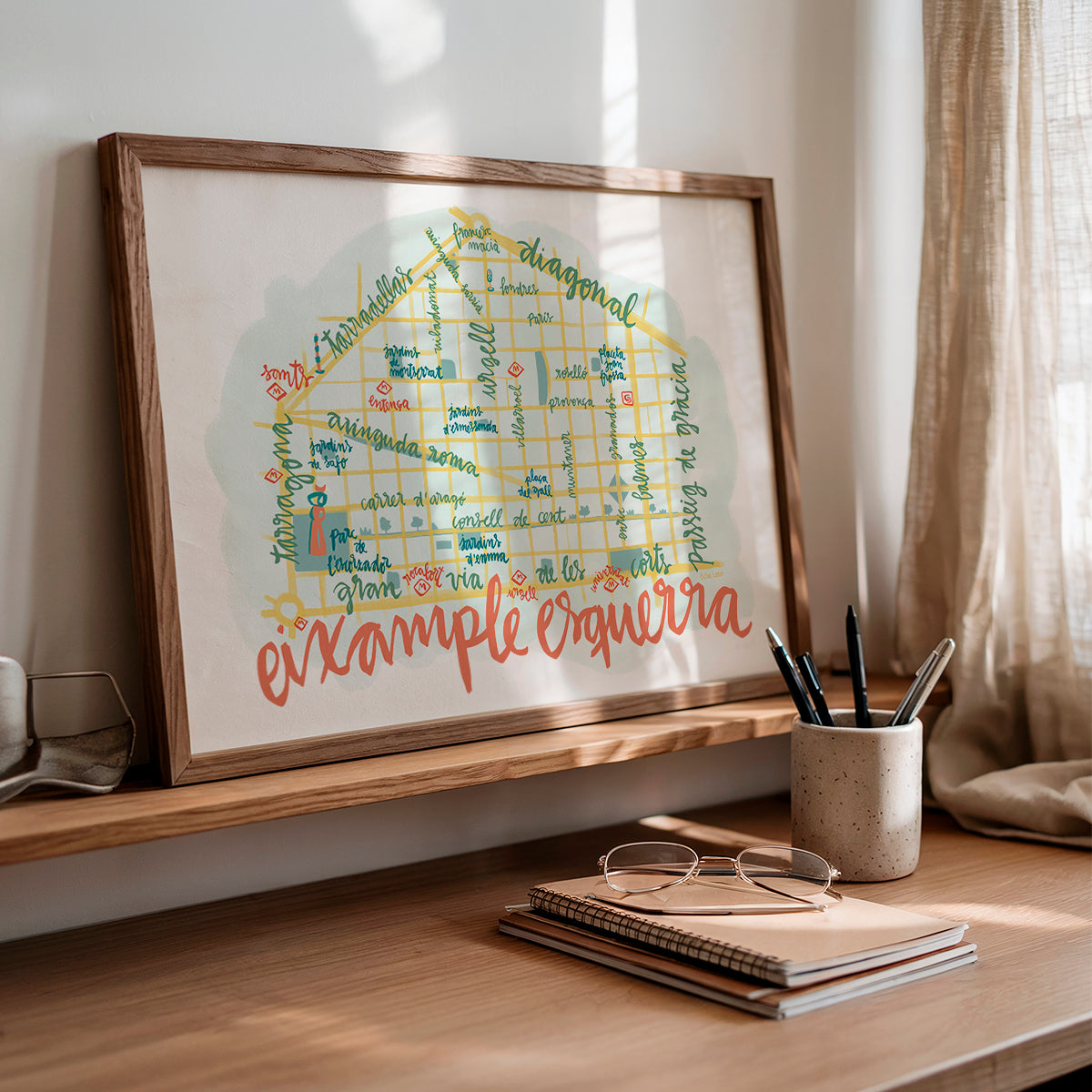 Framed artwork on a shelf with stationery items in the foreground