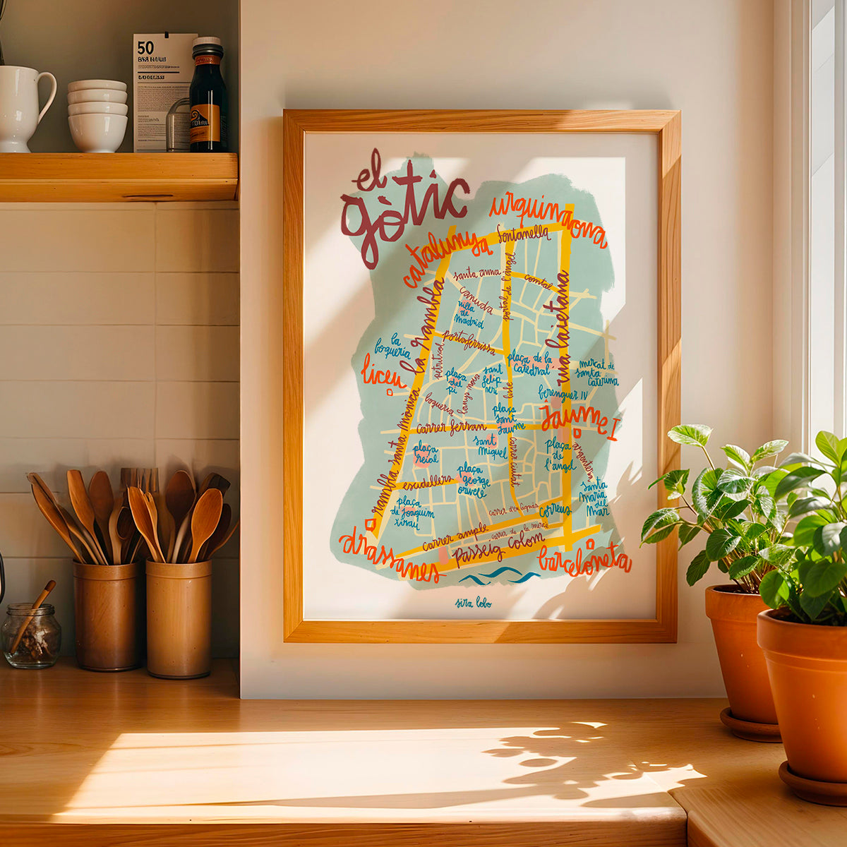 Framed map of Götico neighborhood in Barcelona on a wall in a kitchen.
