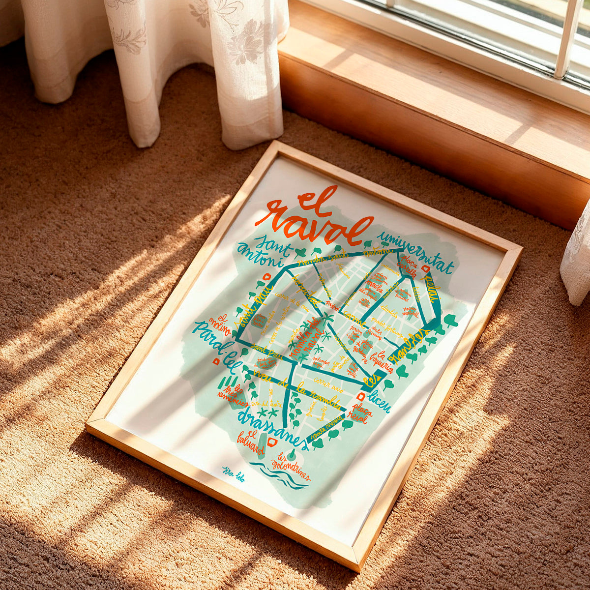 Framed map of El Raval neighborhood in Barcelona on a carpeted floor.