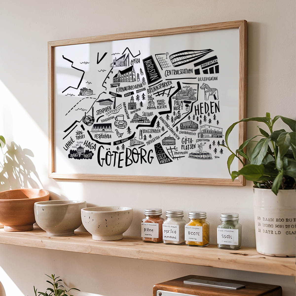 Framed map of Gothenburg on a wall above a shelf with decorative items.