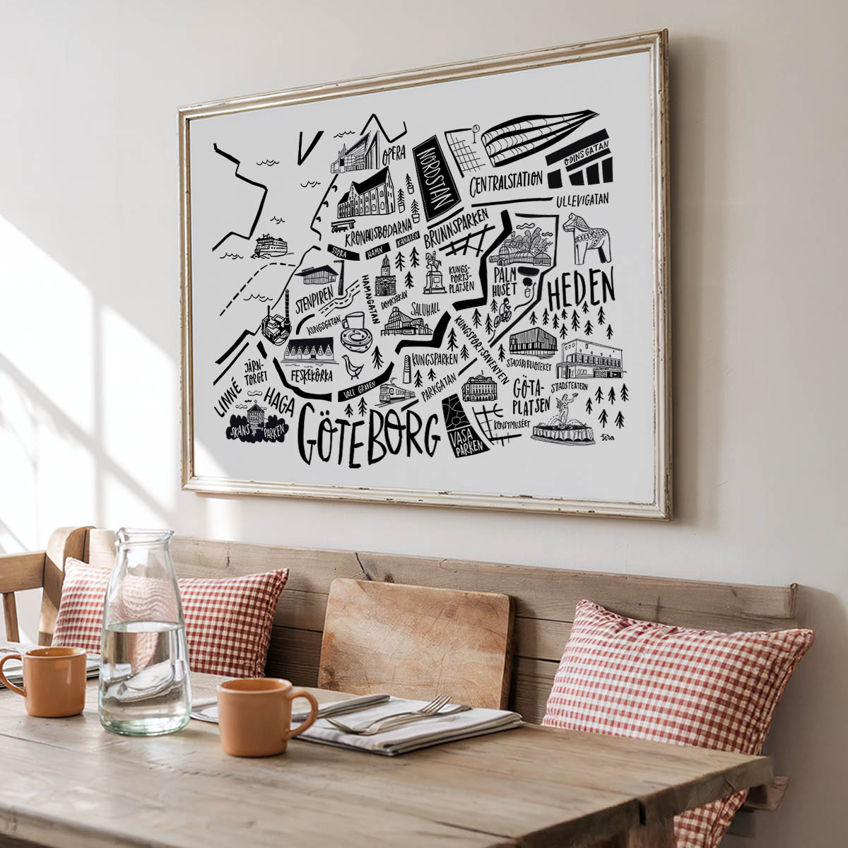 Framed map of Gothenburg on a wall above a wooden bench with a table.