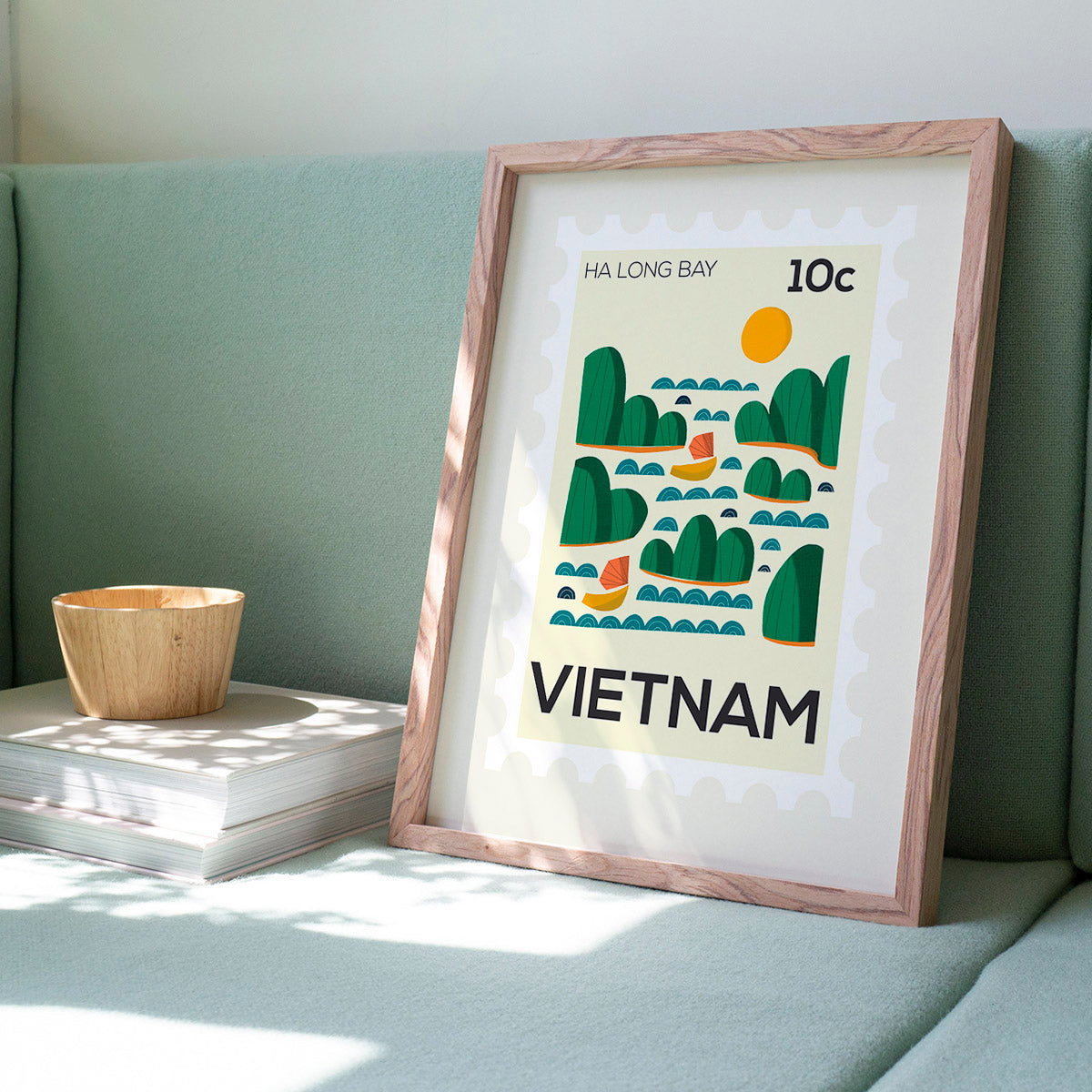 Framed poster of Ha Long Bay, Vietnam on a light green couch.