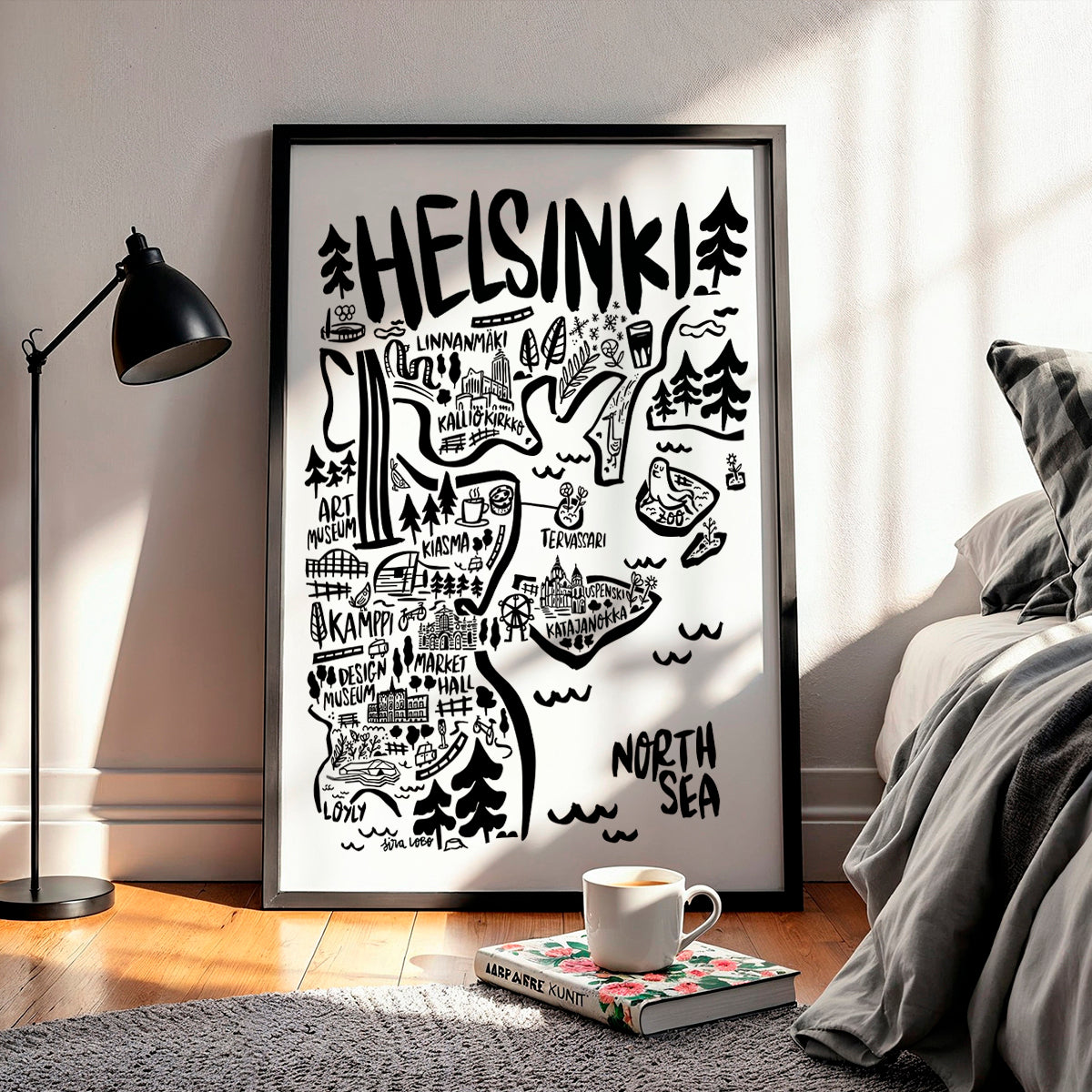 Framed map of Helsinki with black and white design in a room with a lamp and bed.