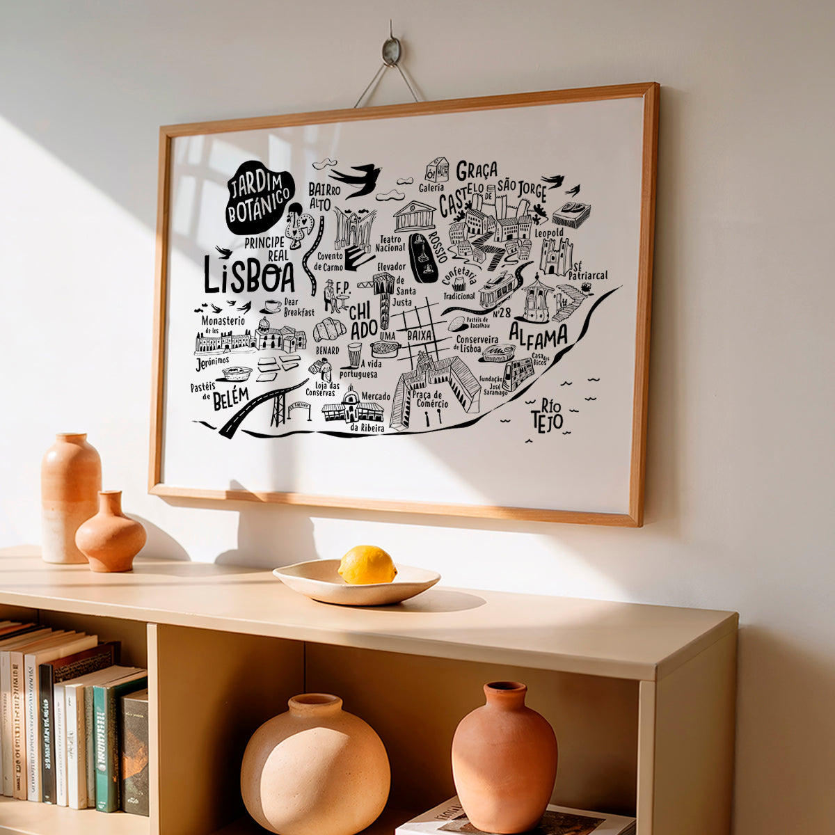 Framed map of Lisbon on a wall above a shelf with decorative items.