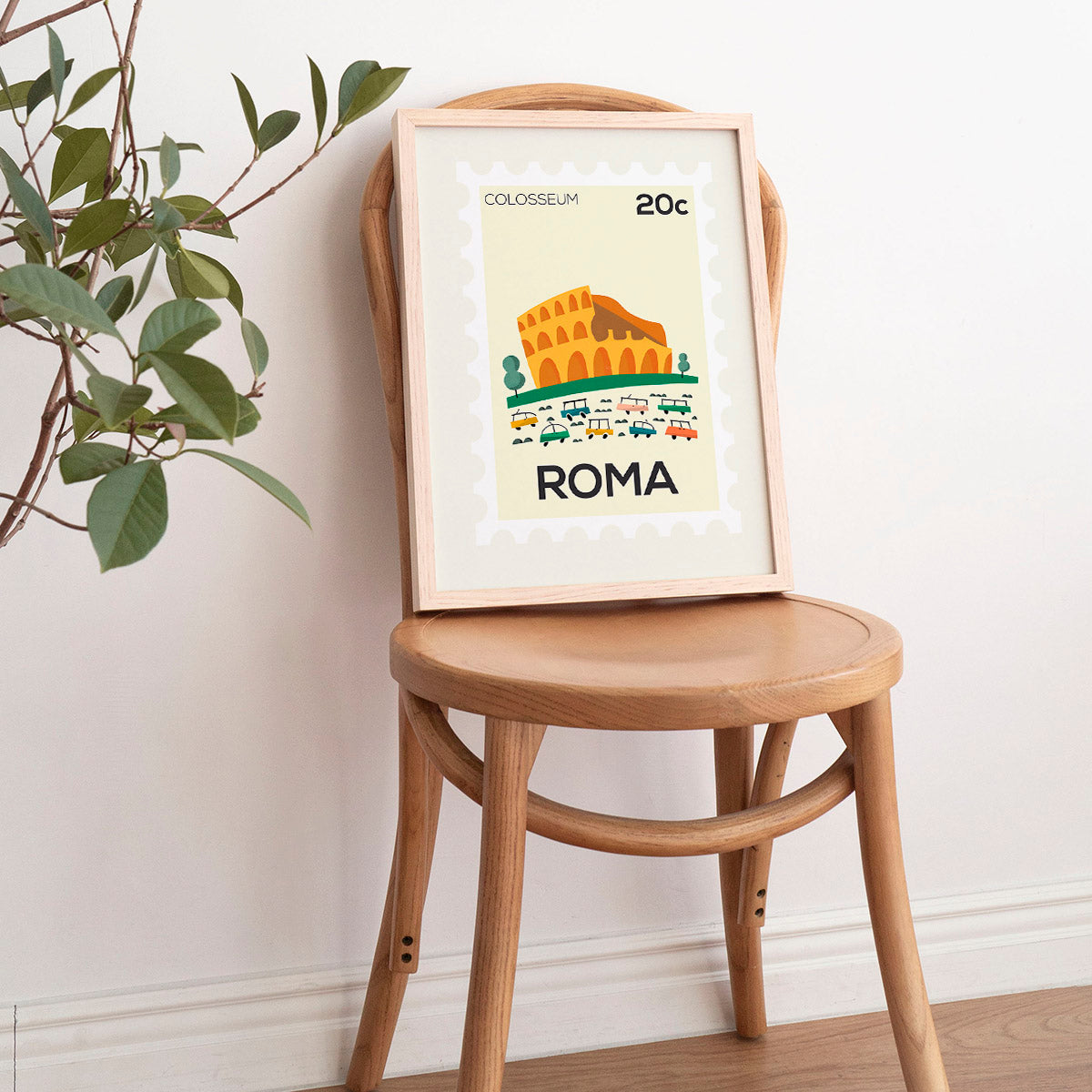 Framed artwork of the Colosseum with 'Roma' text on a wooden chair against a white wall.