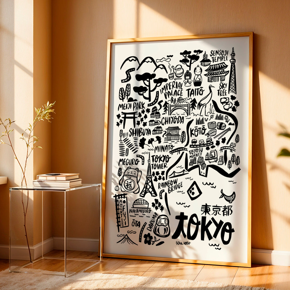 Framed map of Tokyo with landmarks on a wall in a room with a side table and plant.