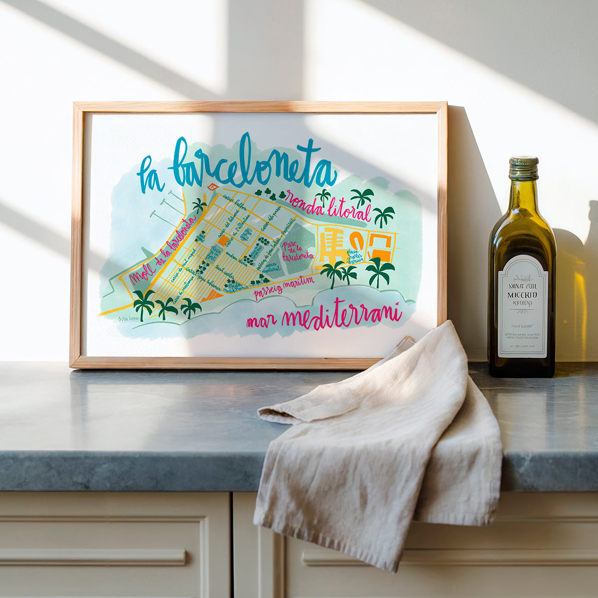Framed map of La Barceloneta on a kitchen counter with olive oil bottle