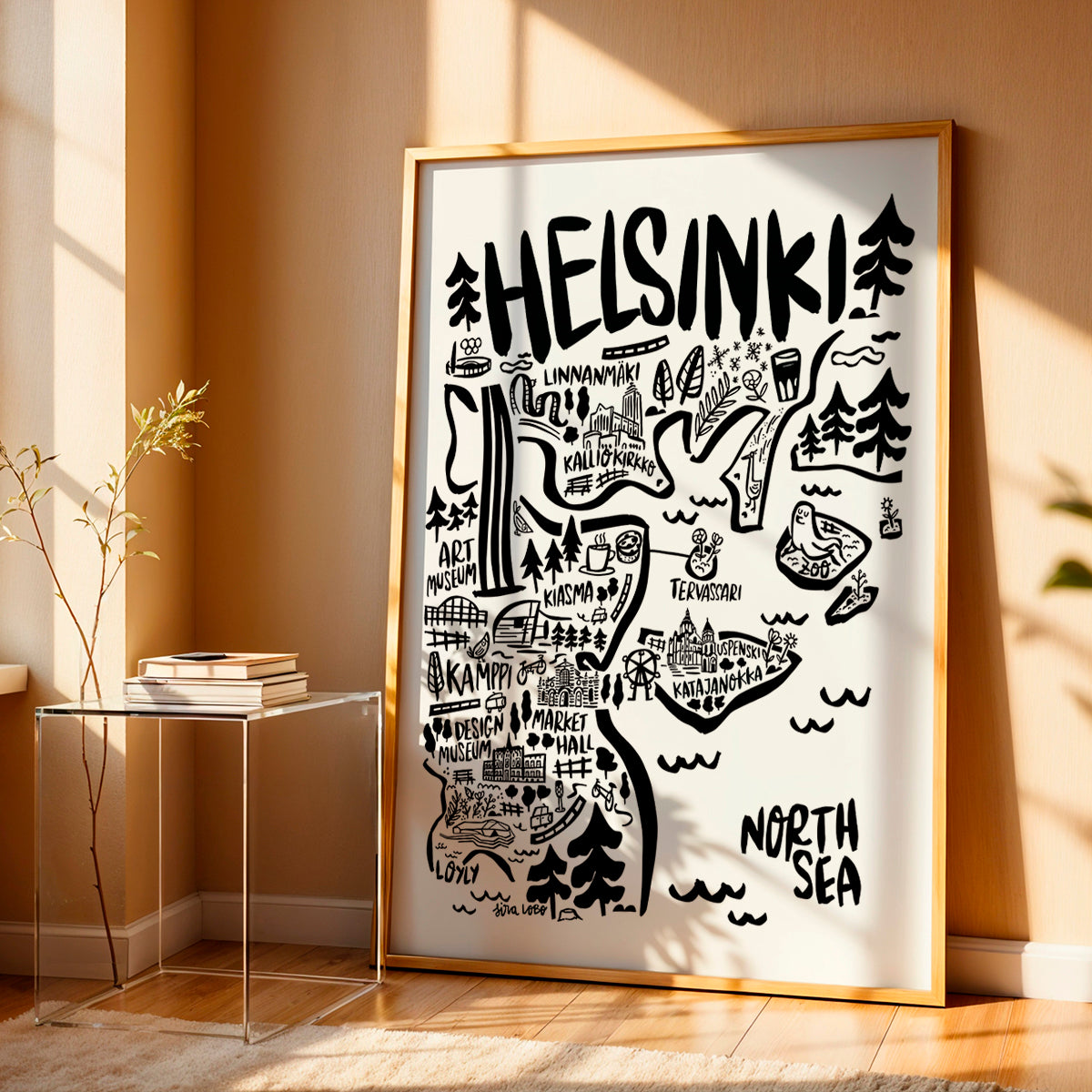 Framed map of Helsinki on a wall in a room with a side table and plant.