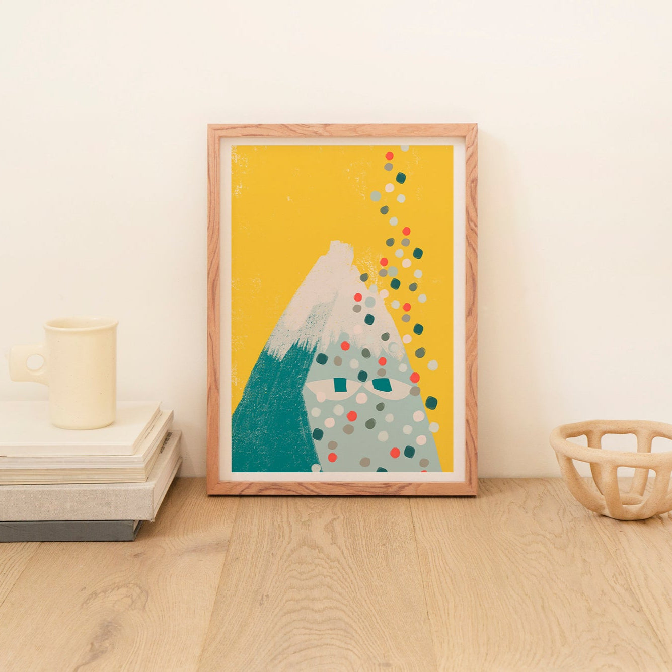 Framed artwork with a mountain design on a wooden surface