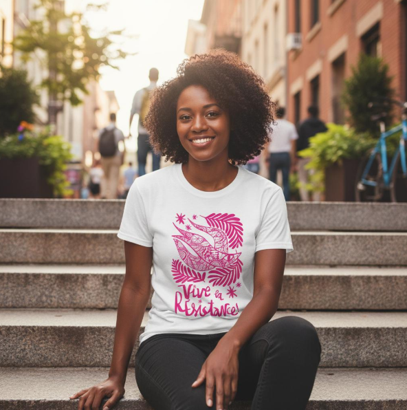Woman wearing a white t-shirt with pink graphic design sitting on steps in an urban setting.