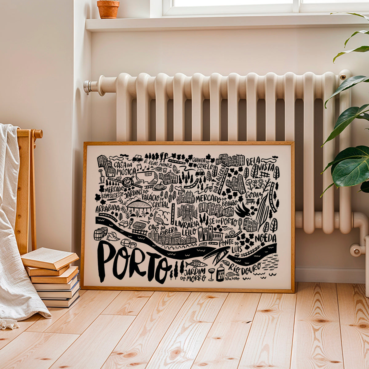 Framed map of Porto on a wall in a room with a radiator and books.