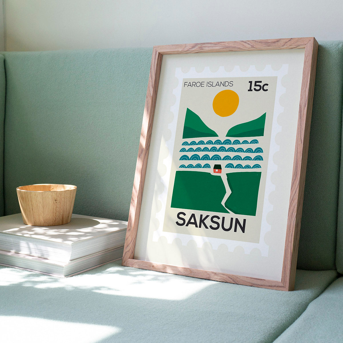 Framed poster of Saksun, Faroe Islands on a light green couch.