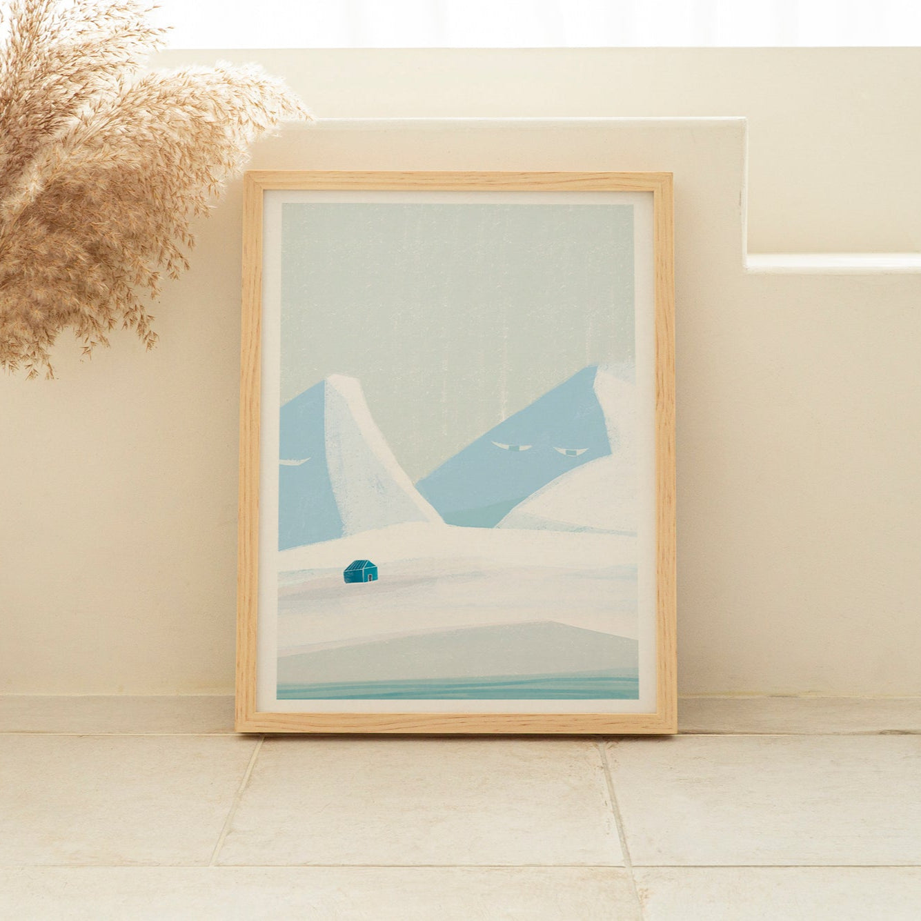 Framed abstract artwork on a white wall with a vase and dried plants.