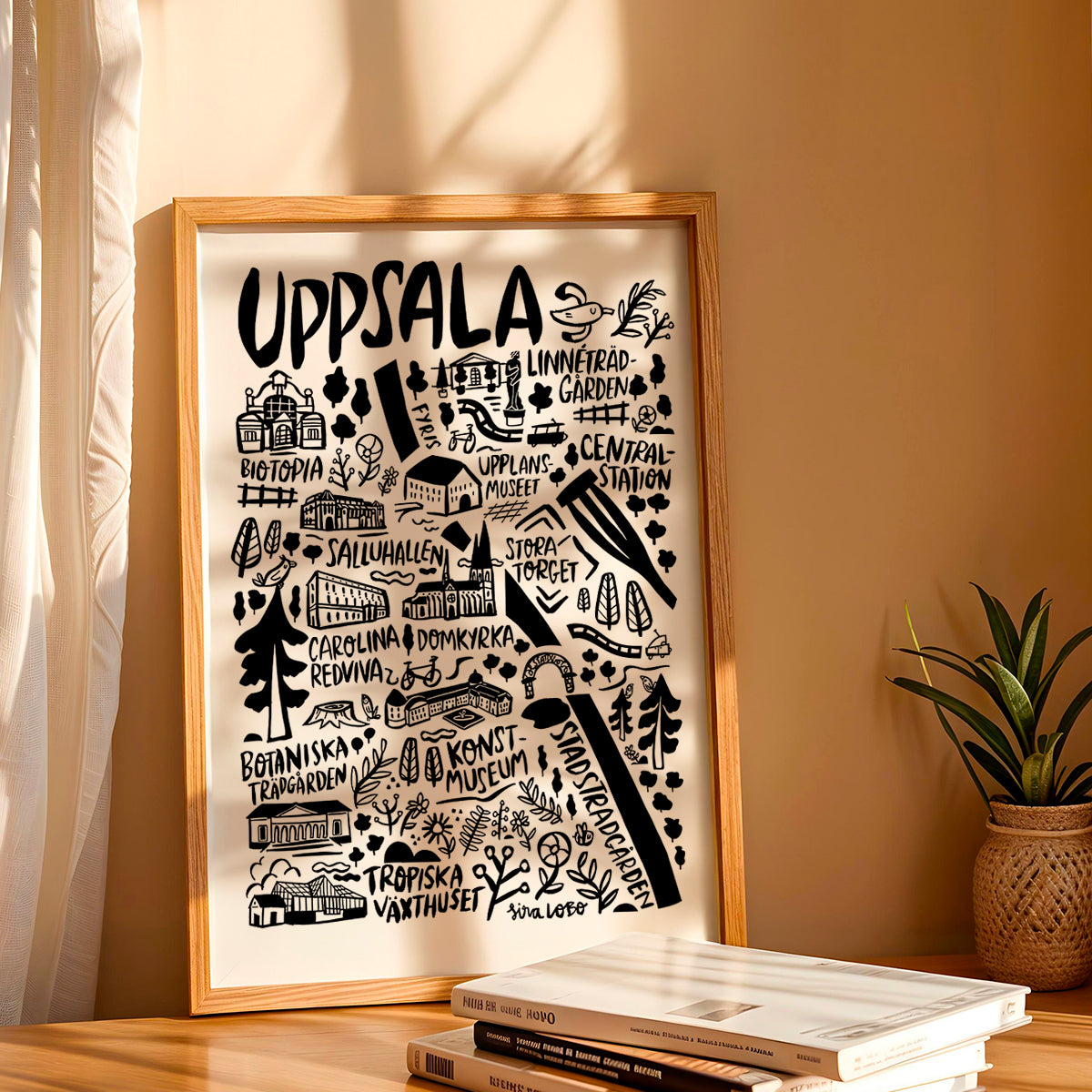 Framed artwork with 'Uppsala' design on a wall with books and a plant below.