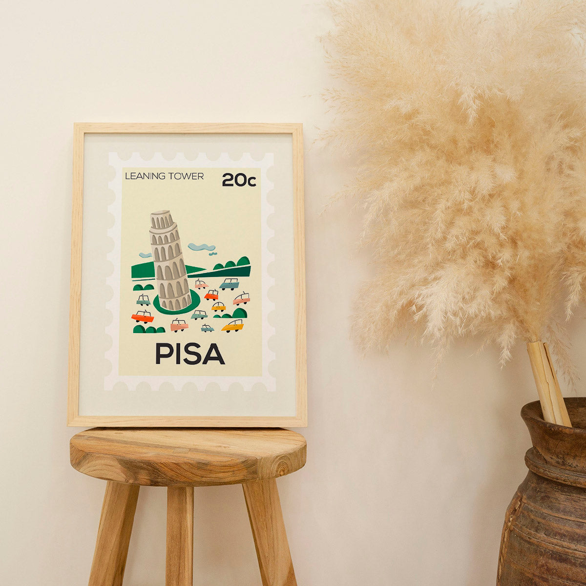 Framed artwork of the Leaning Tower of Pisa on a wooden stool with decorative elements.