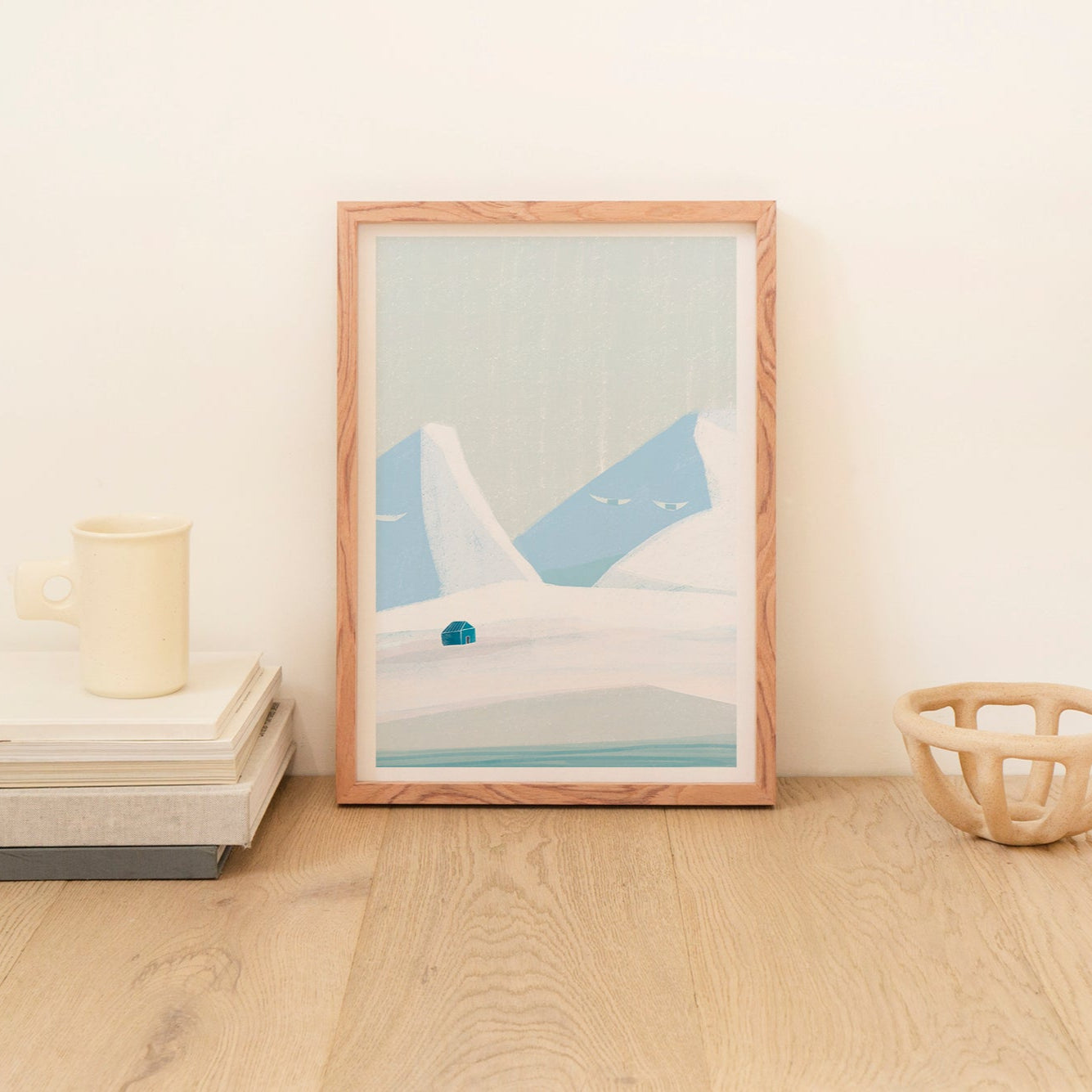 Framed abstract art piece on a wooden surface with minimal decor