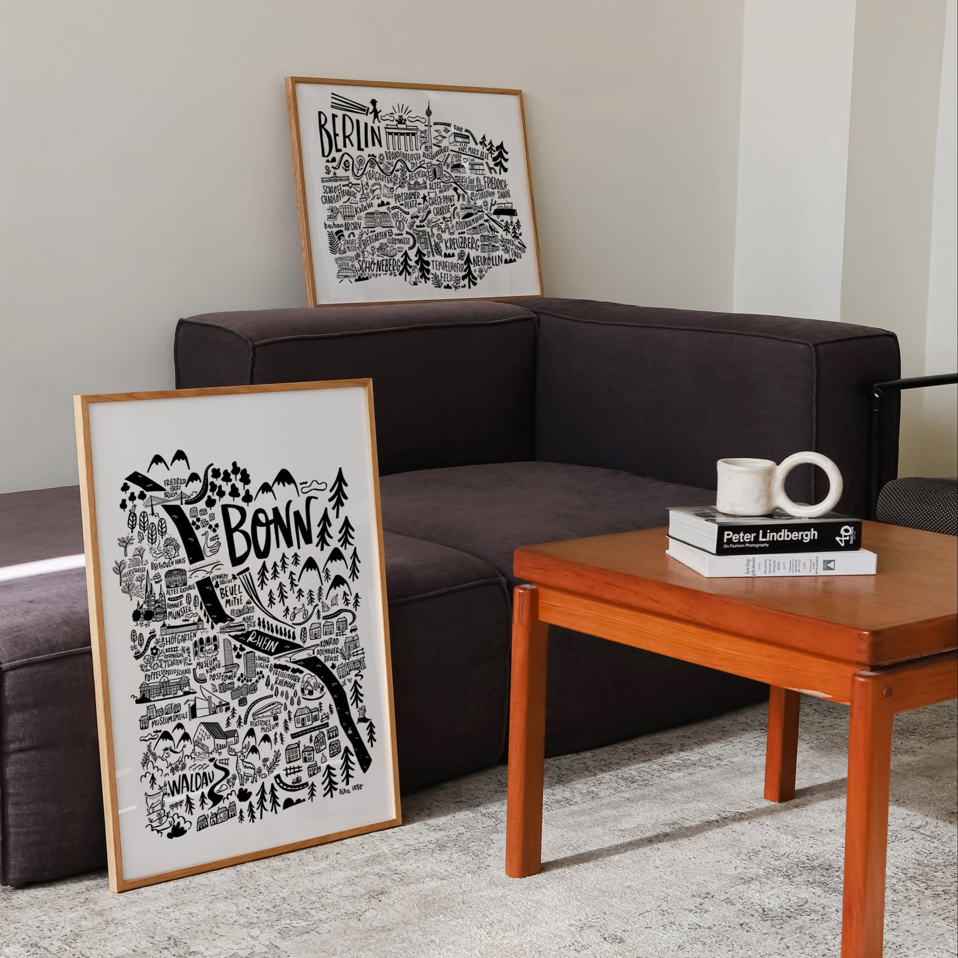 Living room with a brown sofa, wooden coffee table, and framed black and white artwork.