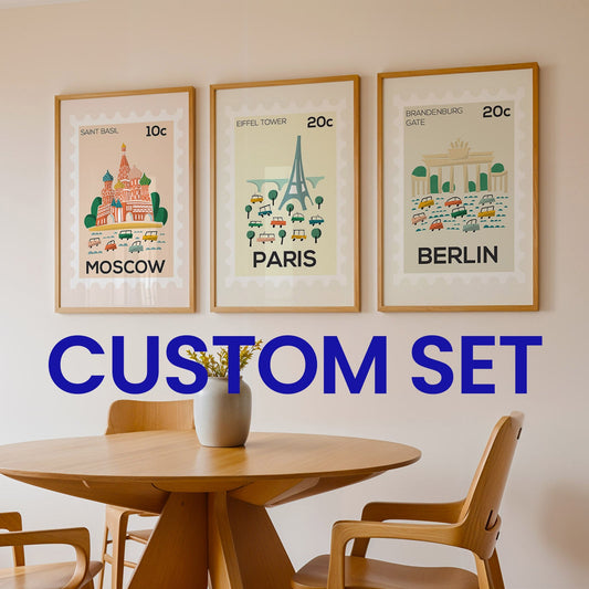 Three framed prints of famous landmarks with 'Moscow', 'Paris', and 'Berlin' text, displayed above a wooden table and chairs.