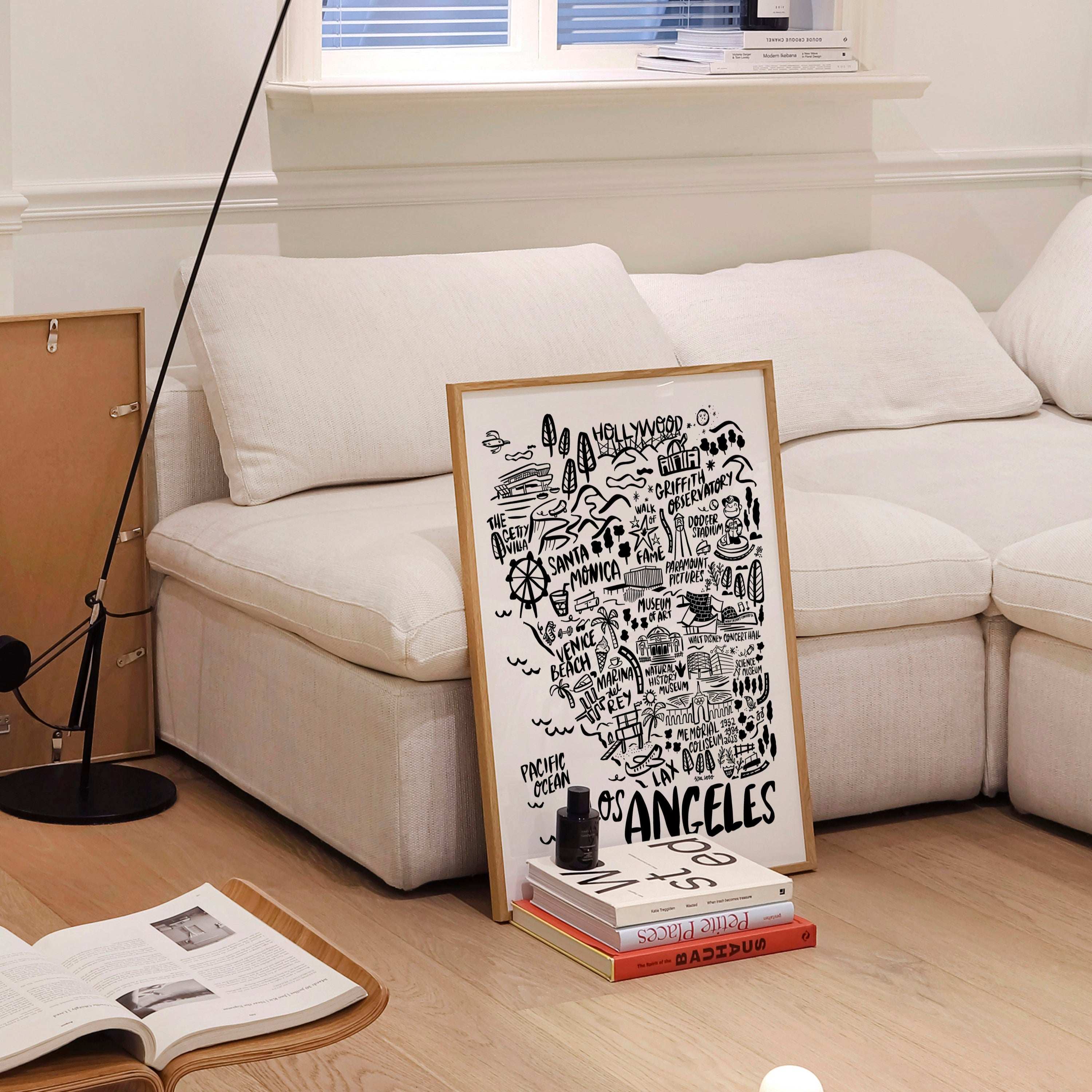 Living room with a white sofa, floor lamp, and a framed poster on a coffee table.
