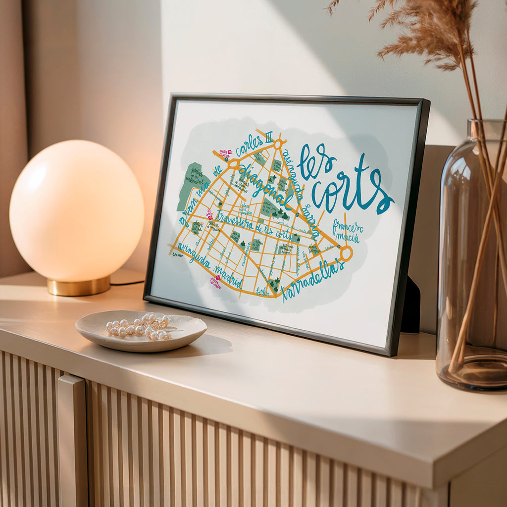 Framed map print of 'les corts' on a shelf with decorative items.