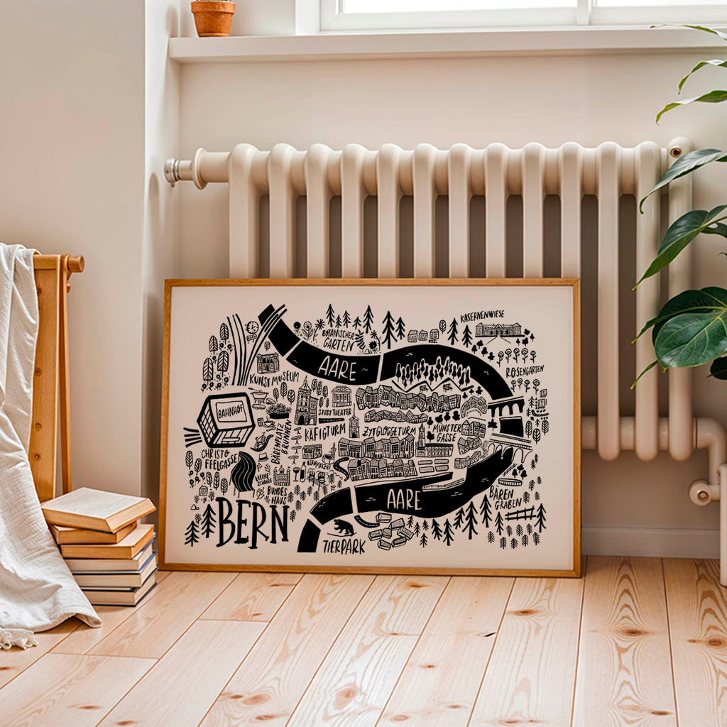 Framed map of Bern on a wall in a room with a radiator and books.