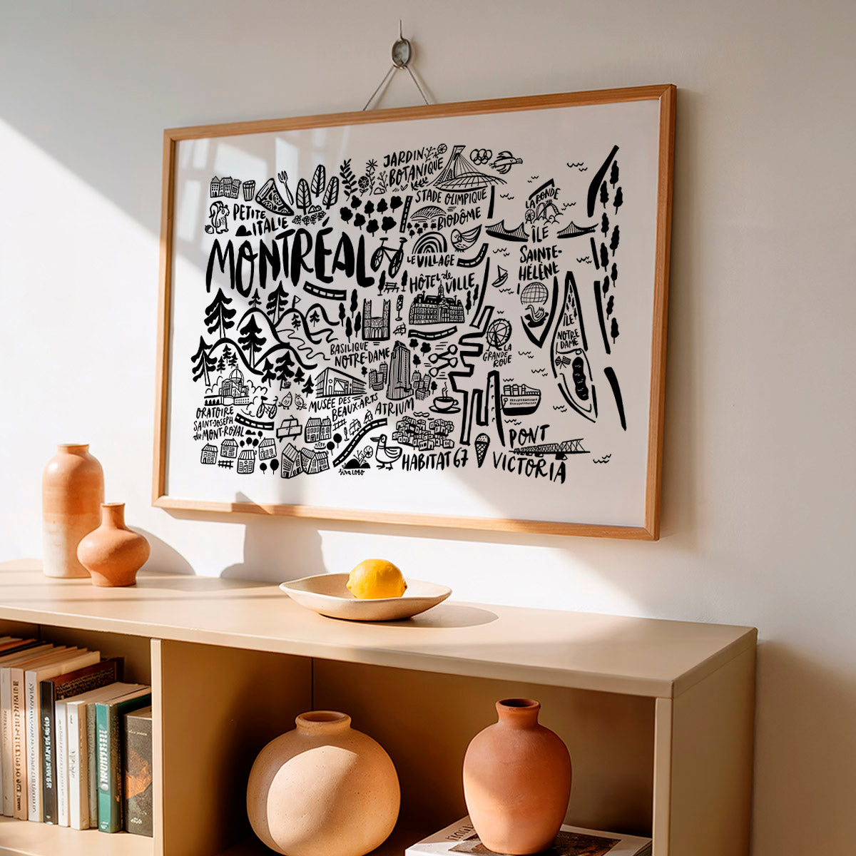 Framed map of Montreal on a wall above a shelf with decorative items.